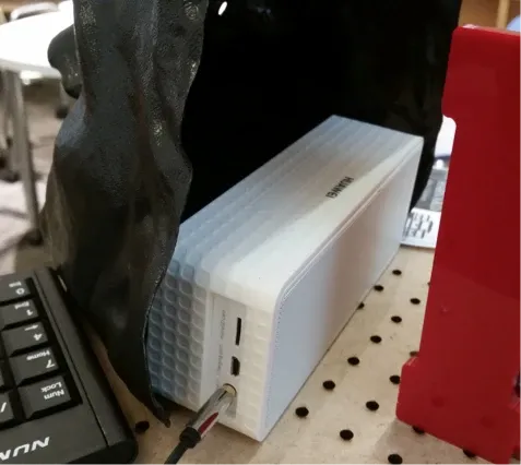 Close-up of the white speaker mounted behind the Waiter Robot’s John Harvard mask.